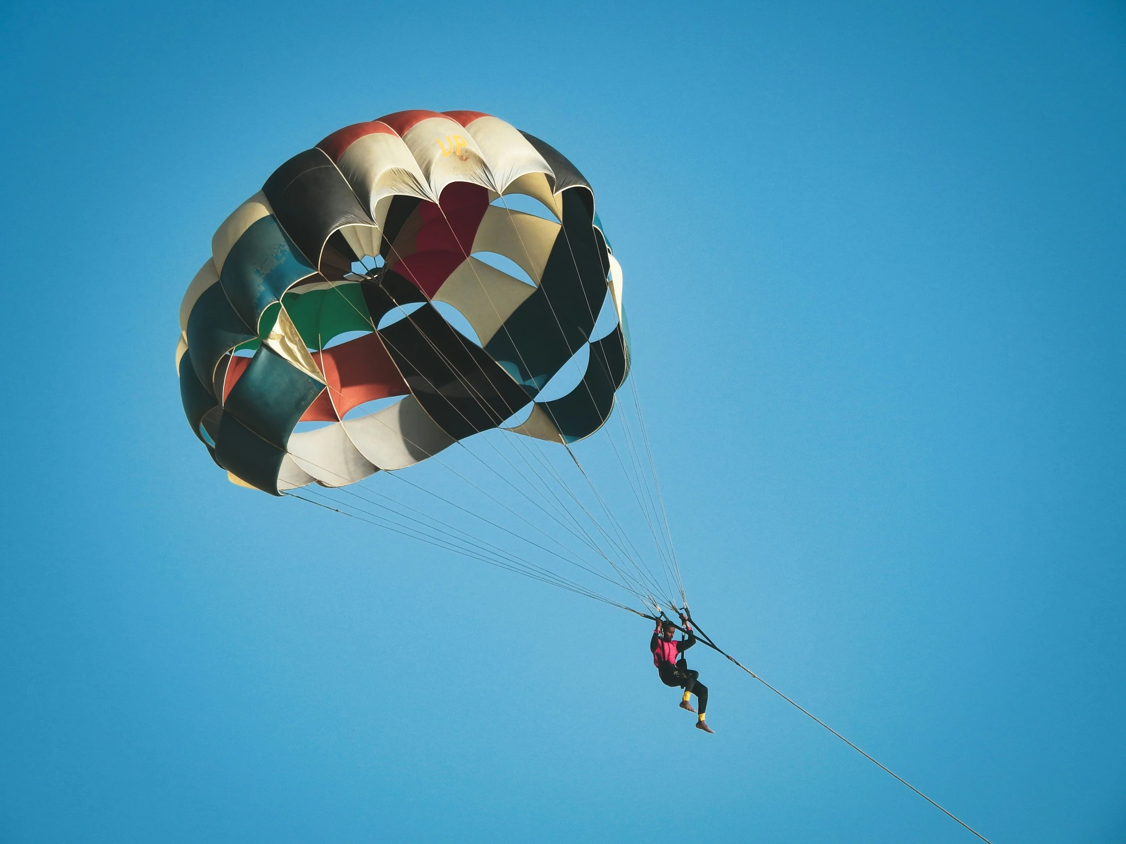 man in full parachute jumping up into the air