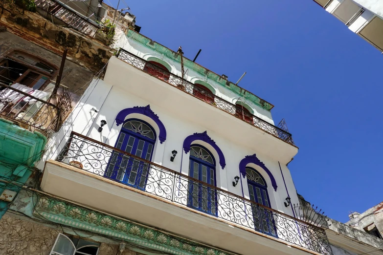 a tall building with many blue windows and some white railings