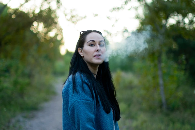 a woman stands on a path in the woods