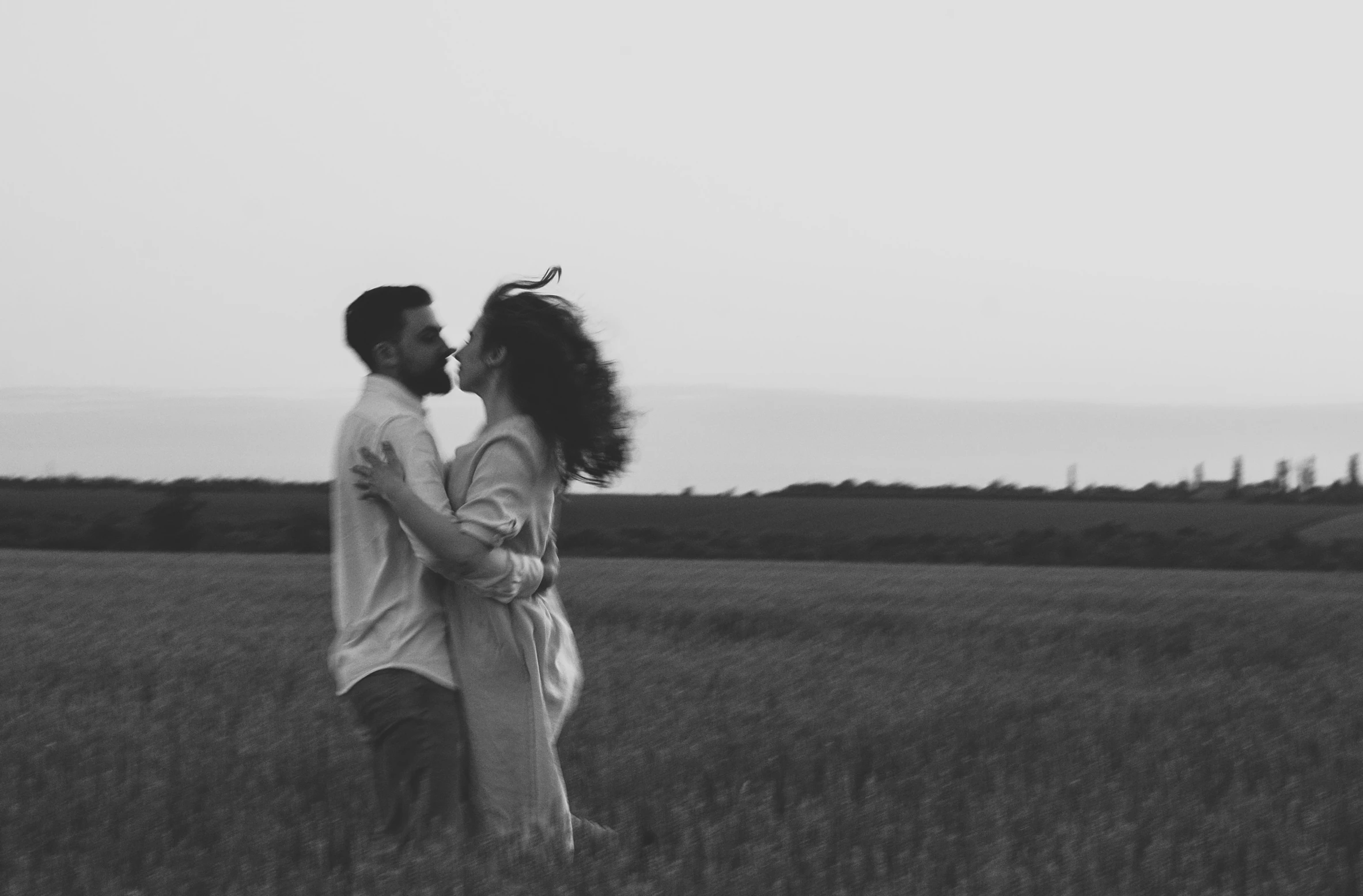 the couple is kissing in the field of tall grass