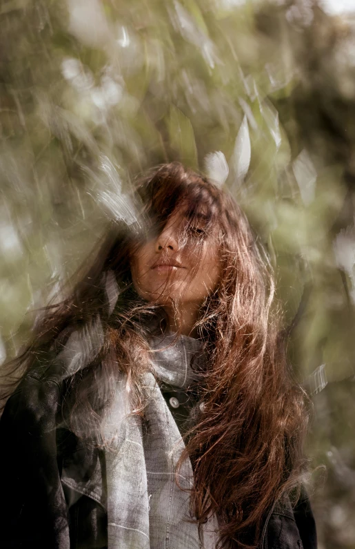 a woman with long hair stands in the rain