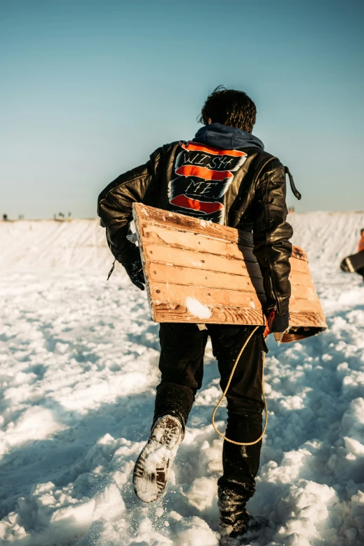 a person walking through snow with a snowboard in their back