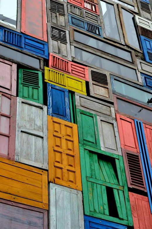 multicolored building with lots of open windows and shutters