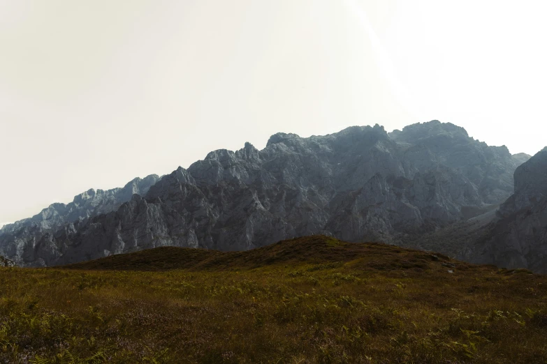 some very tall mountain mountains under a cloudy sky