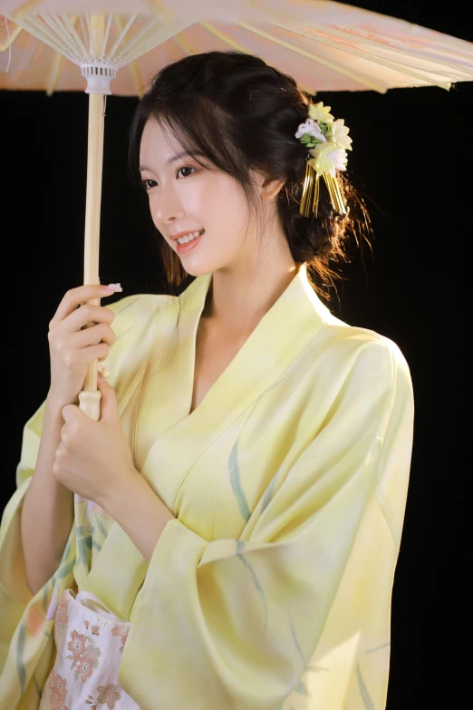 a pretty lady in a yellow kimono holding a parasol