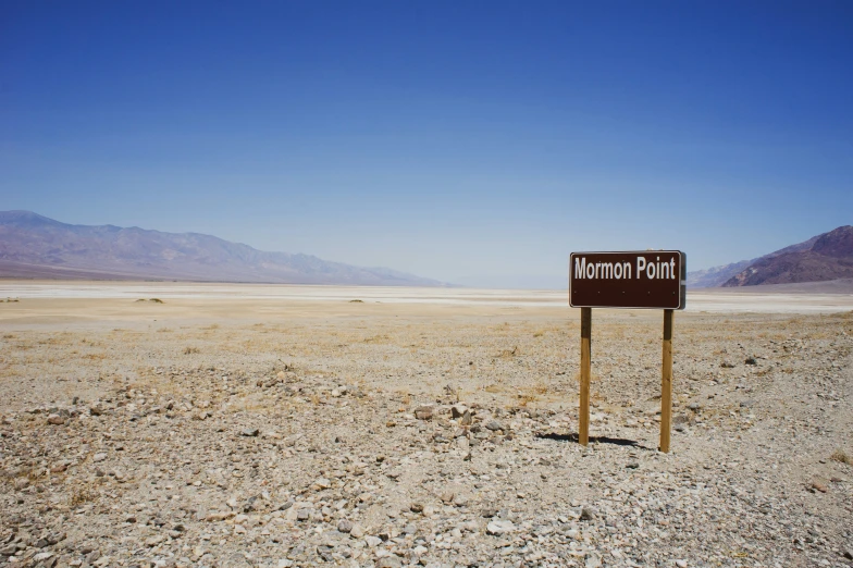 a large sign in the middle of a barren field