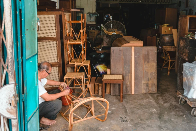 a woman works on a piece of furniture in an old - time shop