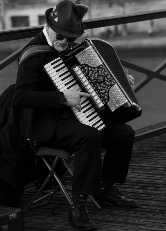 a man is sitting on a bench with a small accordion