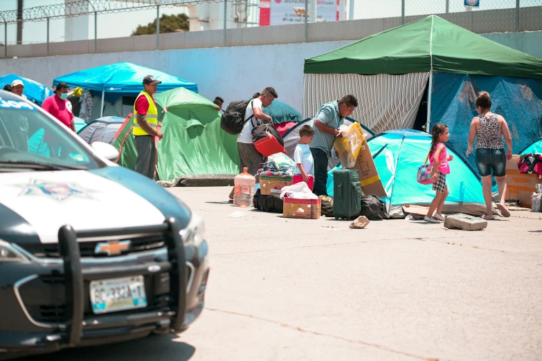 a group of people setting up camp with blue tents