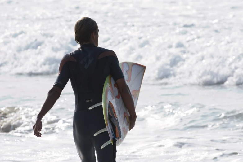 a man in a wet suit is holding a surfboard