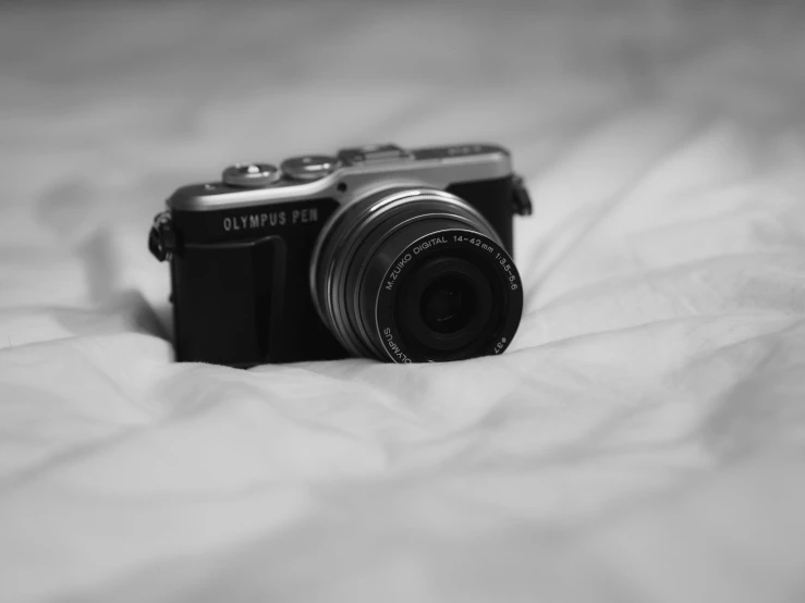 black and white pograph of a camera on a bed