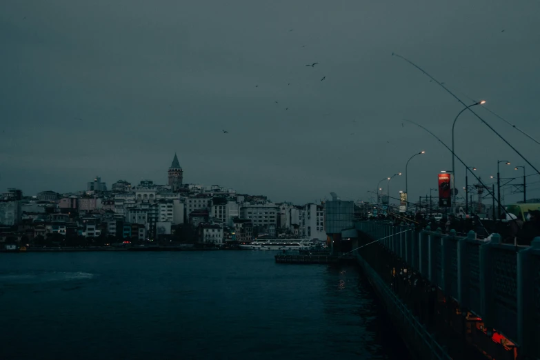 boats sitting in the water near a city under a gray sky