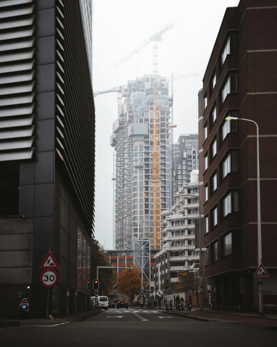 a street in a busy city with tall buildings under construction