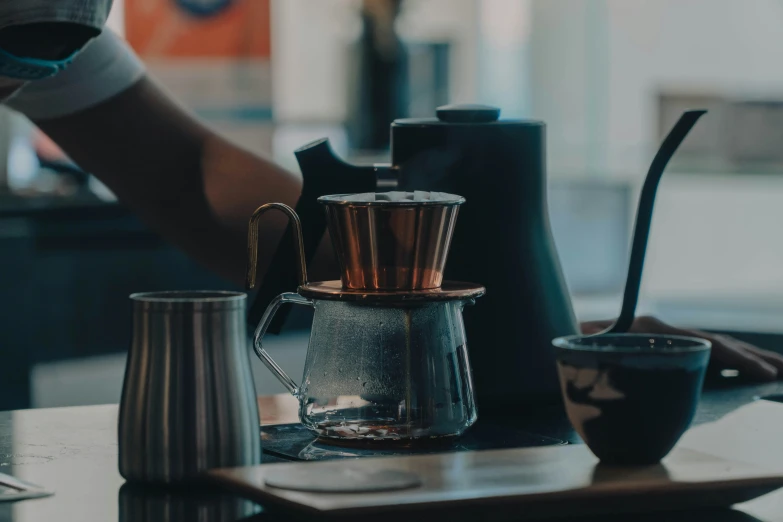 a close up of a person holding an object near a mug