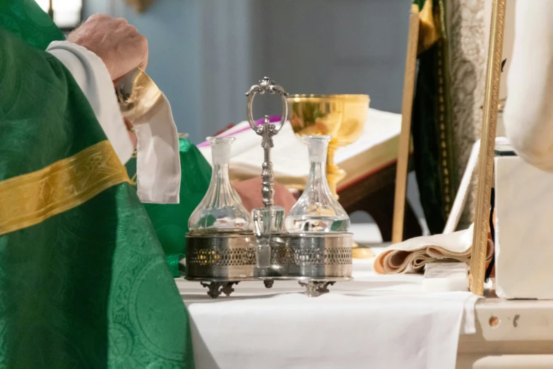 a priest lights a silver candle during the mass