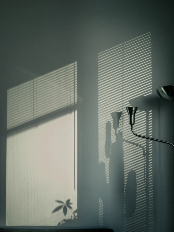 a couple in shadow near a lamp and a window