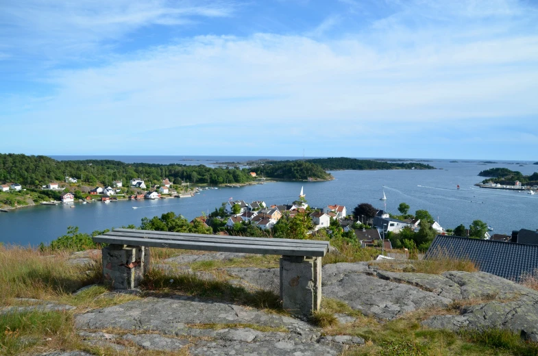 a wooden bench overlooks the beautiful town of a swedish seaside