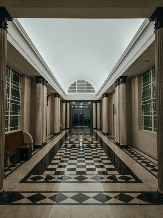 the hallway inside a building is tiled and very empty