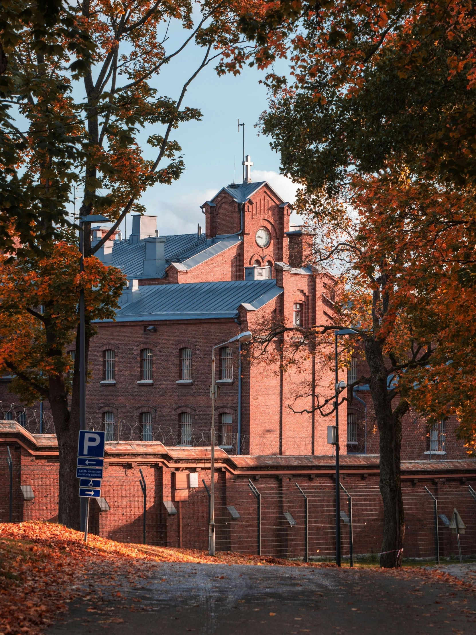 a red brick building with a tower with a blue roof