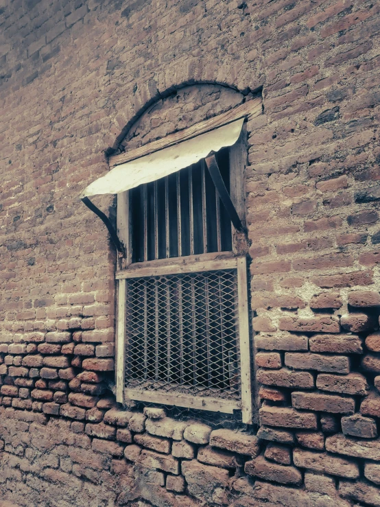 the wall and window are made of red bricks