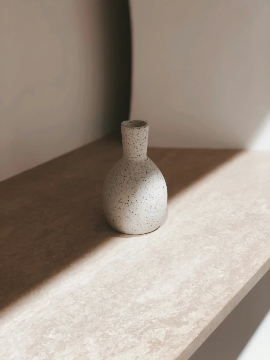 the vase is on the white surface in the room