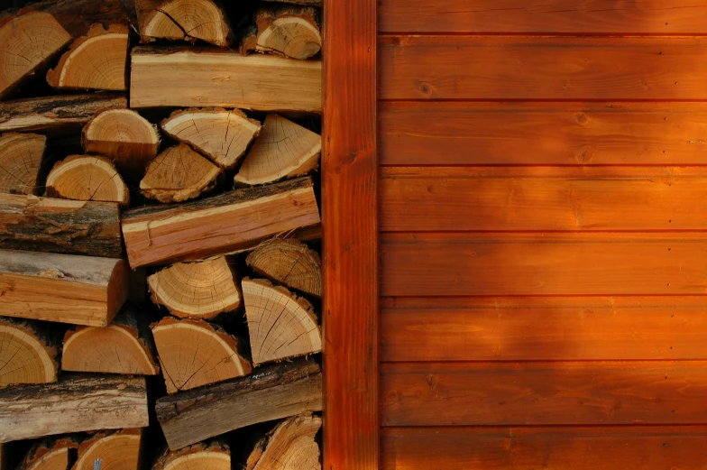 a stack of wood sitting next to a wooden shed