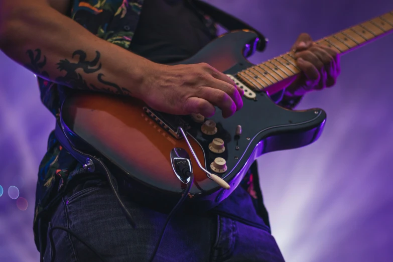 a man in black shirt playing guitar on stage