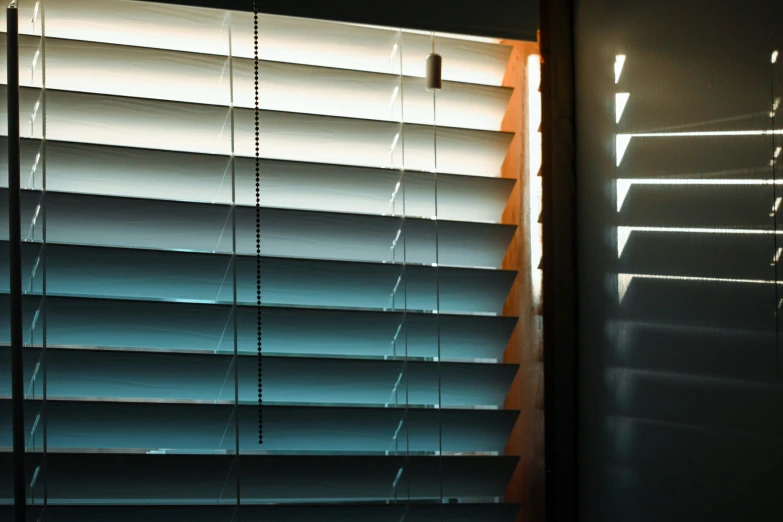 white light shining through an open window with blinds