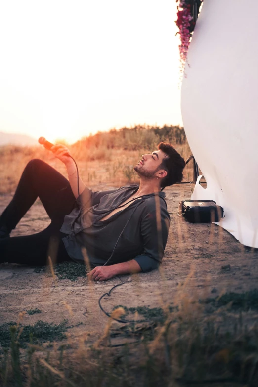 a man laying on the ground with his hair dryer