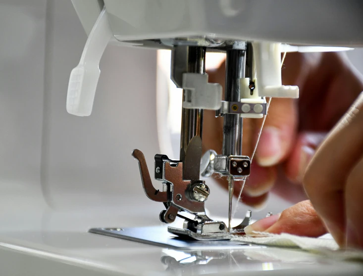 a person working on a sewing machine and some papers