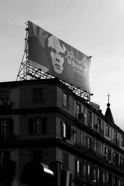 a poster of a person has been placed on the side of a tall building