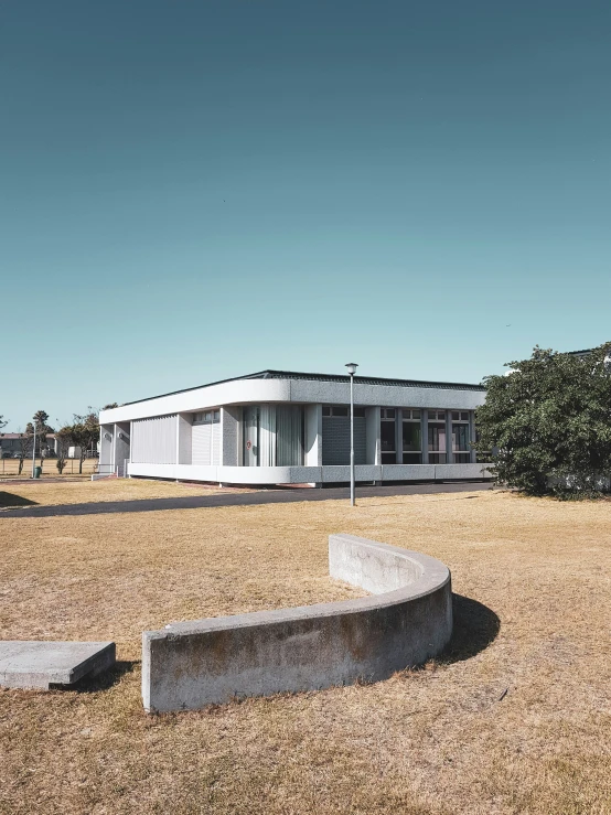 an empty field with cement benches near a building