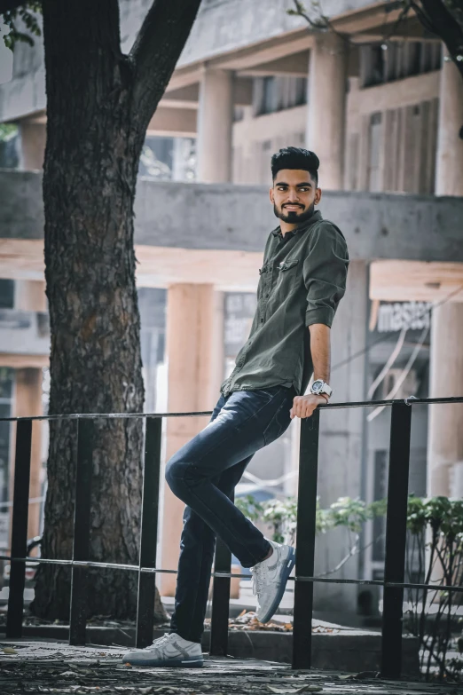 a man standing on a fence next to a tree