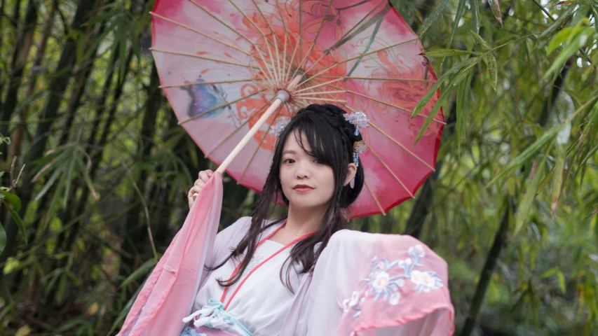 a woman dressed in traditional clothing holding an umbrella