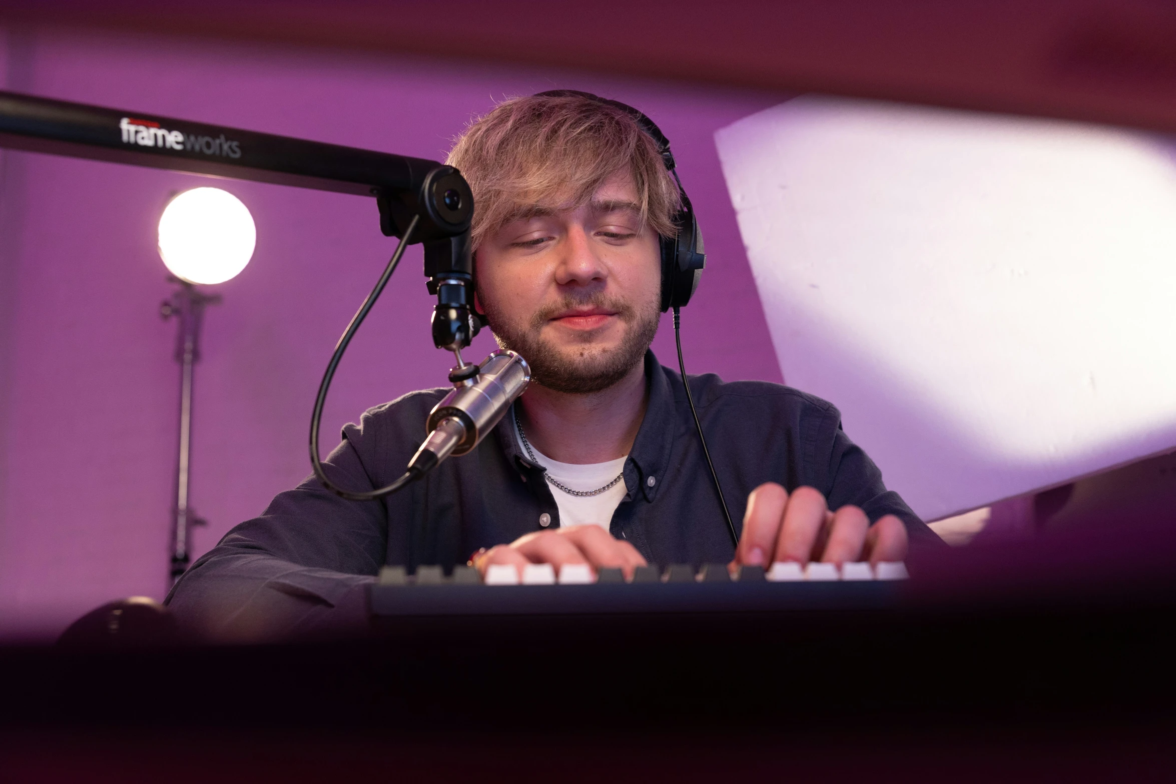 a man wearing headphones on top of a keyboard