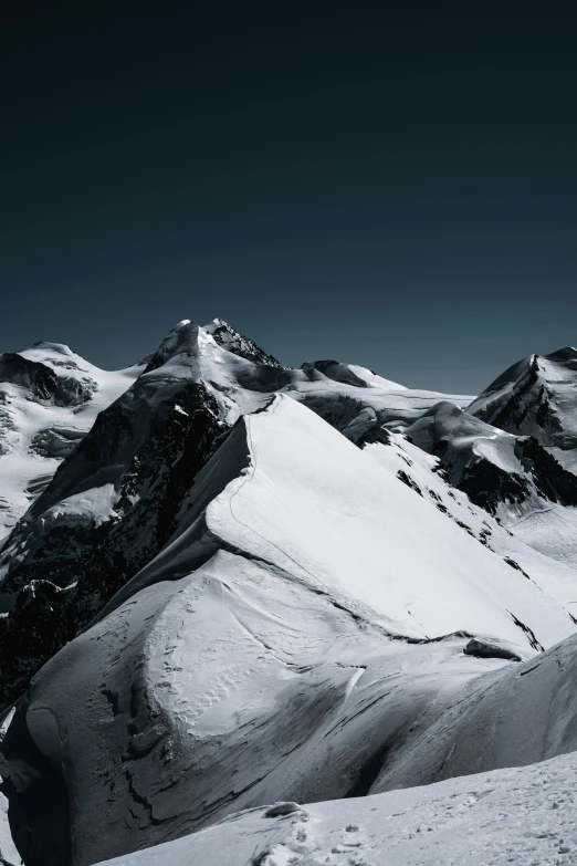 a large snowy mountain covered in snow with mountains and trees