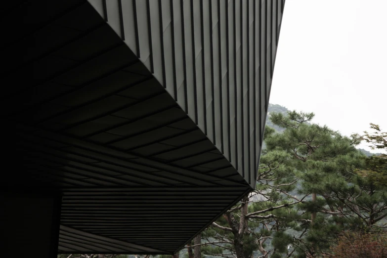 view of trees and clouds from underneath an architectural building