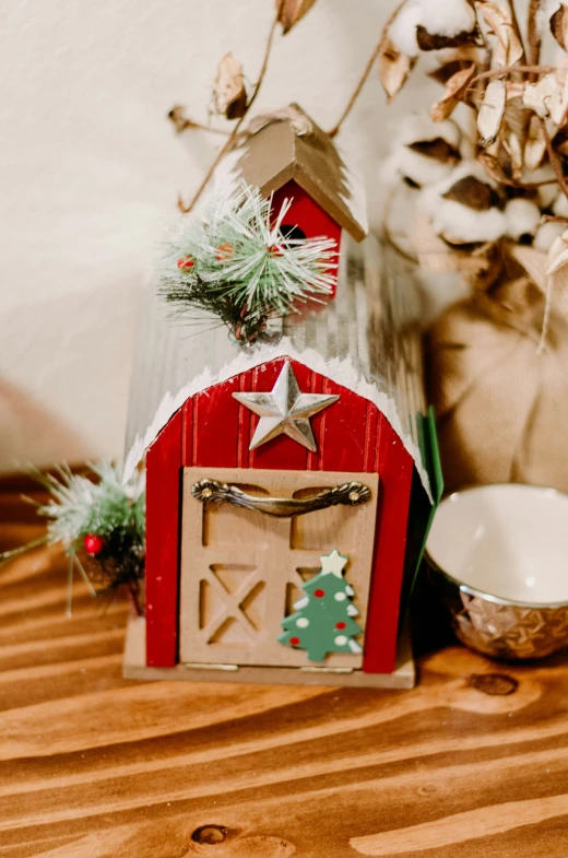 a wooden box with a red barn on top