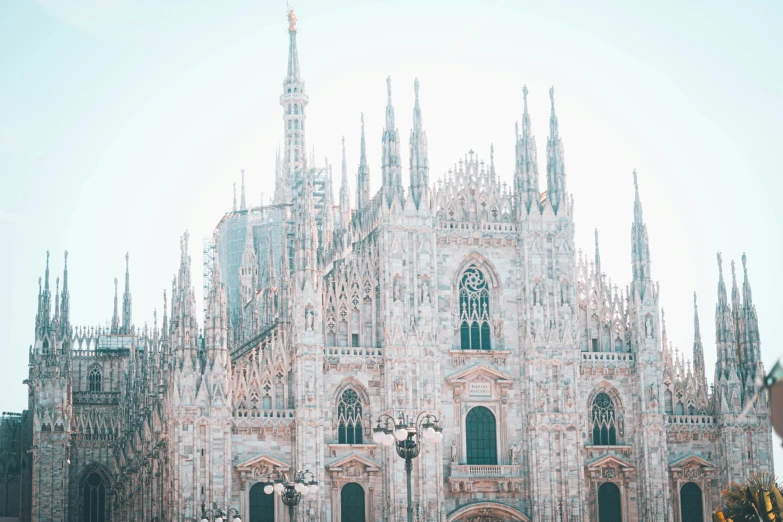 a cathedral with spires and statues in front