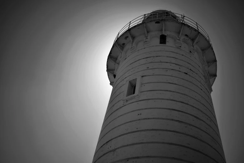 a large white lighthouse tower against a gray sky