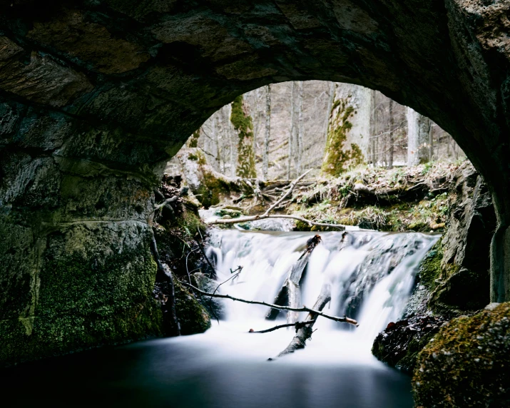 there is a river going underneath an old brick bridge