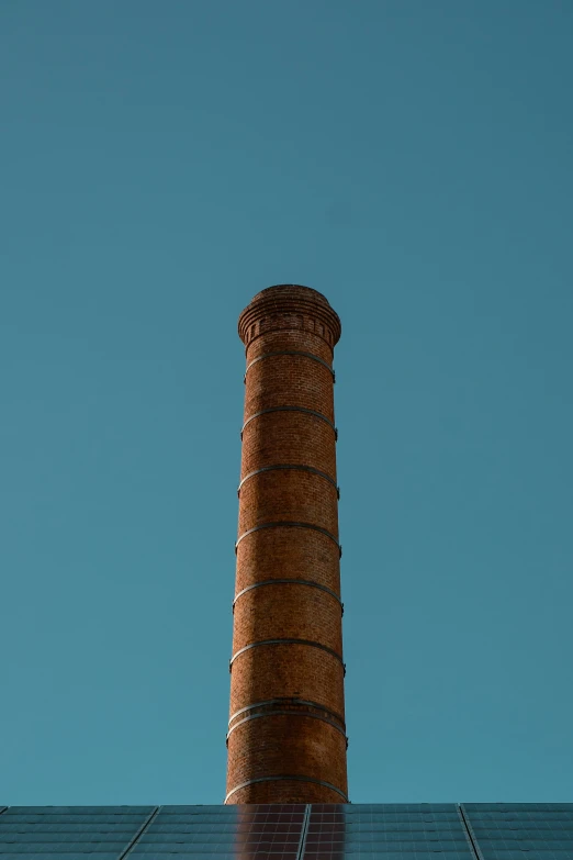 the top of a red brick chimney against a blue sky