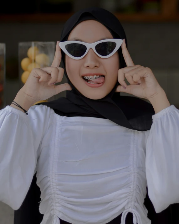 a woman is wearing sunglasses and a hijab