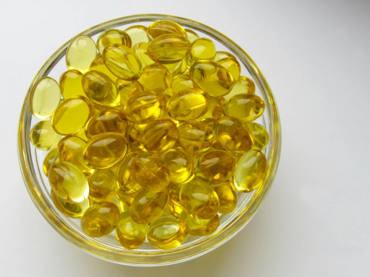 some glass yellows are in a bowl on a white table