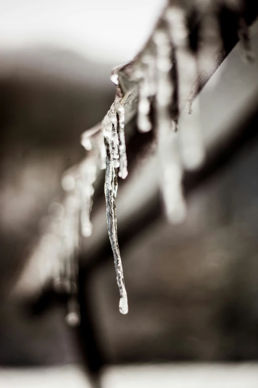 some icey water hanging from the side of a bench