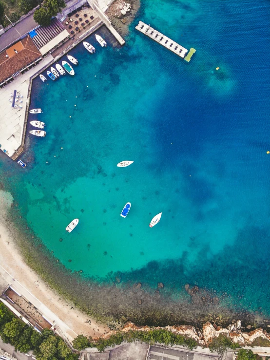 several boats are docked near the turquoise waters