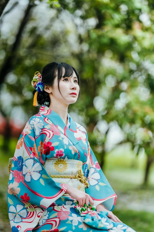 an oriental woman in blue outfit posing for a picture