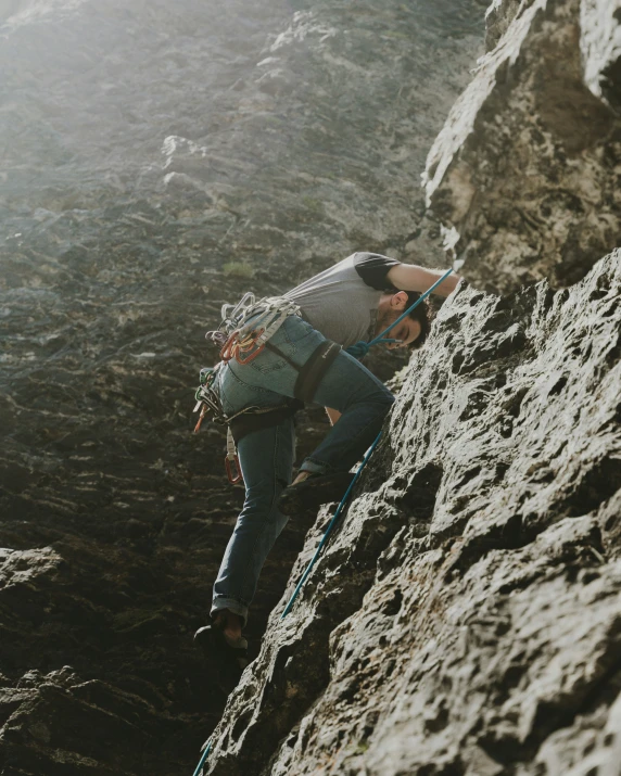 a man on a mountain climbing to the summit