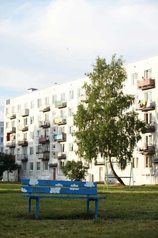 the two blue benches are in front of a white building