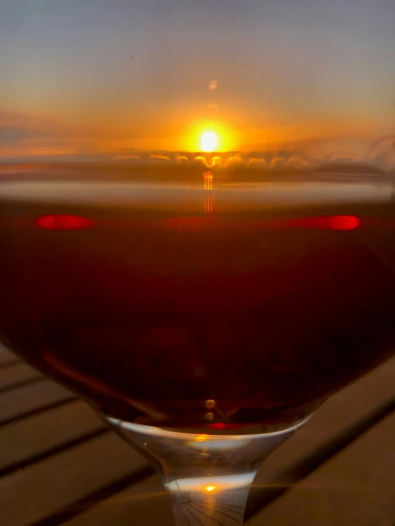 the sun set behind the horizon in the glass